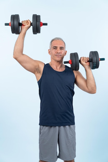 Foto tiro de cuerpo entero hombre mayor activo y deportivo levantando mancuernas durante el entrenamiento con pesas entrenamiento en fondo aislado físico activo saludable y estilo de vida de cuidado corporal para jubilado clout