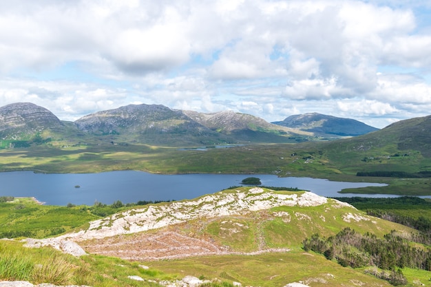 Tiro da paisagem das montanhas e do lago contra o céu nublado, connemara, irlanda.