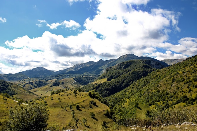 Tiro de alto ângulo da paisagem montanhosa com camadas de picos vistos sob céu nublado