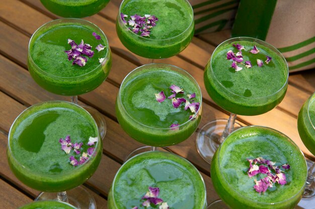 Tiro de alto ângulo de um monte de smoothies de vegetais verdes em uma superfície de madeira