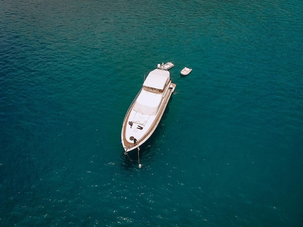 Tiro de drone do belo iate branco no mar azul quente; conceito de riqueza.