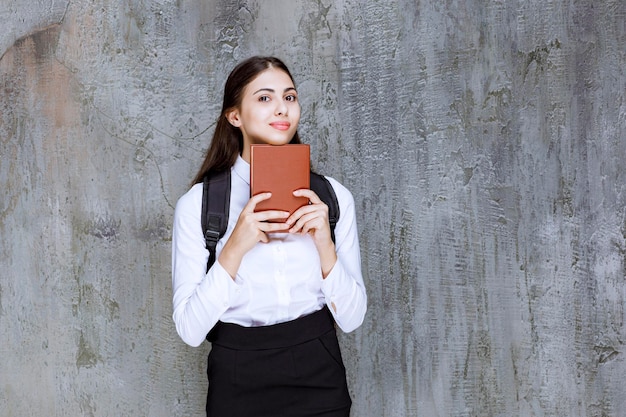 Tiro de linda adolescente com mochila segurando o livro. foto de alta qualidade