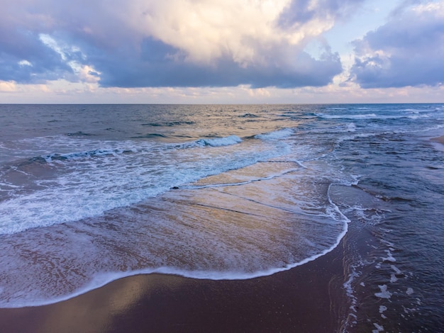 Tiro de um drone voador sobre o mar com um céu dramático antes de uma tempestade