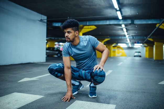 Tiro de um homem atleta americano africano se preparando para um treino.