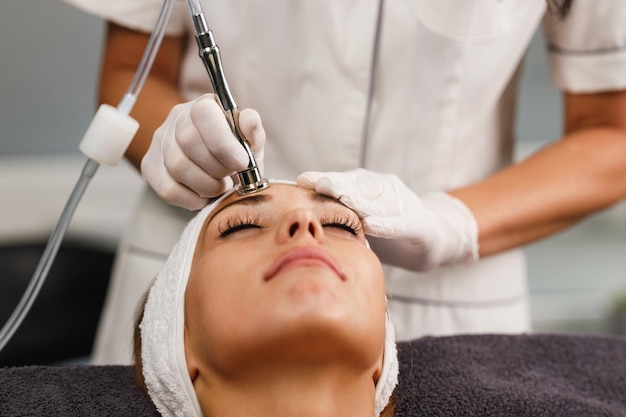 Foto tiro de uma bela jovem em um tratamento facial de microdermoabrasão no salão de beleza.