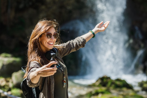 Tiro de uma jovem sorridente, aproveitando o dia na natureza.