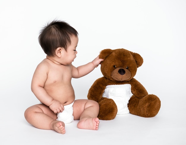 Tiro del estudio de un bebé con un oso de peluche