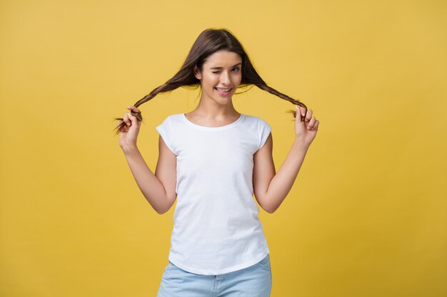 Tiro del estudio de la muchacha caucásica encantadora aislada en fondo amarillo.