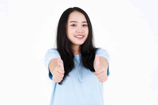 Tiro de estudio de retrato de modelo femenino de pelo largo negro regordete joven asiático en camiseta casual azul y pose y en acción de publicidad que muestra la presentación del producto sobre fondo blanco