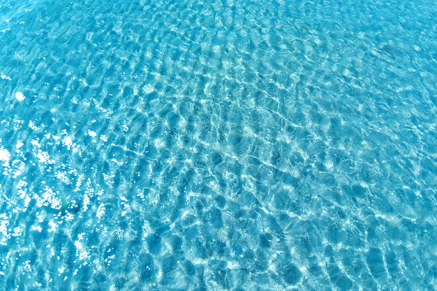 Tiro del fondo de la superficie del agua del aqua. Piscina con reflejos soleados.