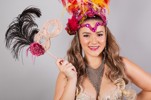 Tiro horizontal de medio cuerpo hermosa mujer brasileña en ropa de carnaval con máscara de carnaval