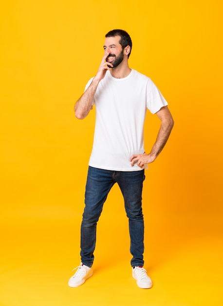 Tiro integral del hombre con barba sobre amarillo aislado sonriendo mucho