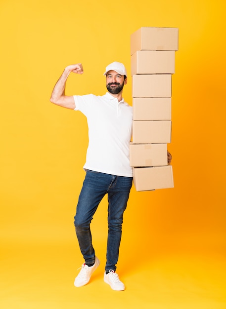 Tiro integral del repartidor entre cajas sobre amarillo aislado