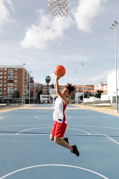 Foto tiro largo de niña jugando baloncesto