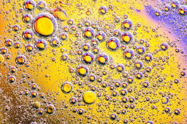 Tiro macro de burbujas de aceite con agua sobre fondo de colores. Planetas del espacio y del universo con estilo de imagen abstracta.