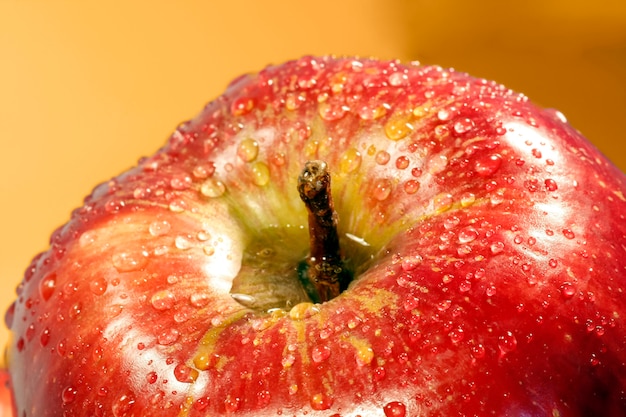 Tiro macro de una manzana roja con gotas del agua.