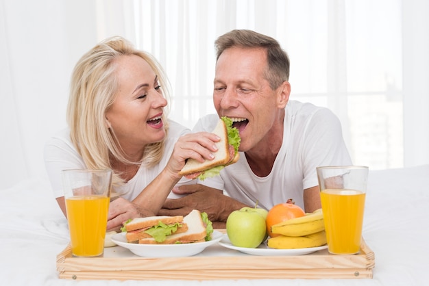 Foto tiro médio casal feliz comendo juntos