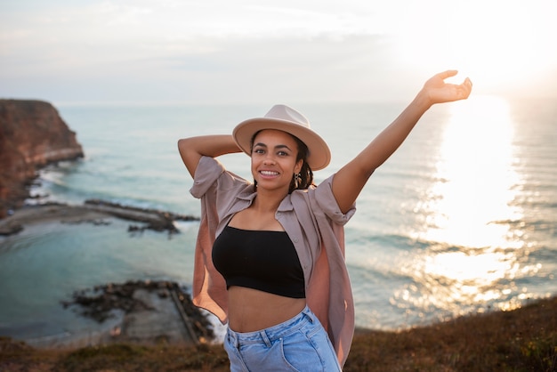 Tiro médio da mulher do smiley que veste o chapéu