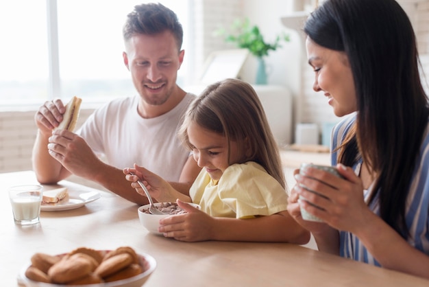 Tiro medio, familia comiendo juntos