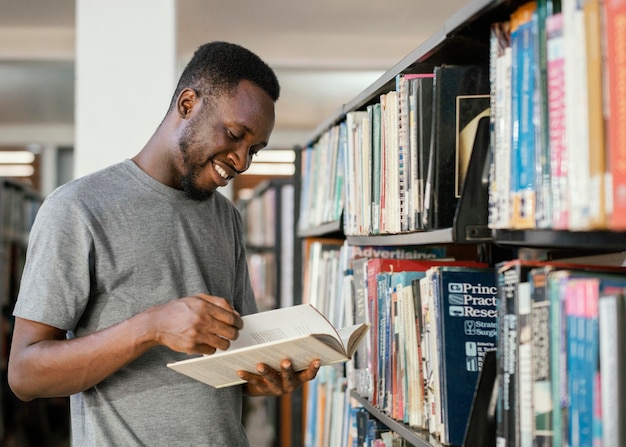 Foto tiro medio del libro de lectura del estudiante sonriente