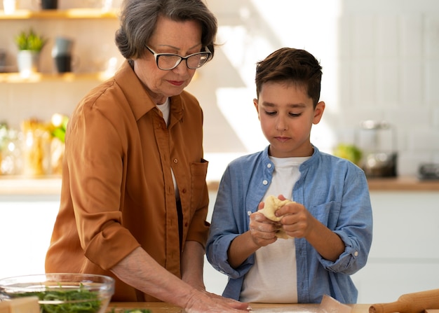 Tiro medio mujer y niño cocinando juntos