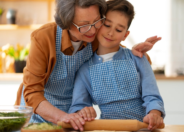 Tiro medio mujer y niño cocinando juntos