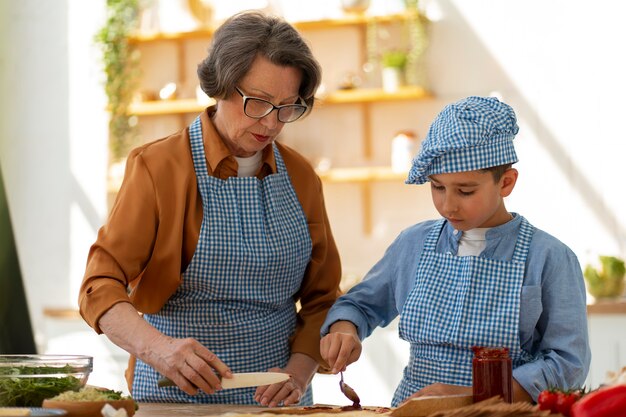 Tiro medio mujer y niño cocinando juntos