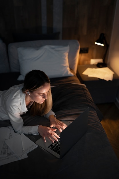 Foto tiro medio mujer que trabaja en la computadora portátil