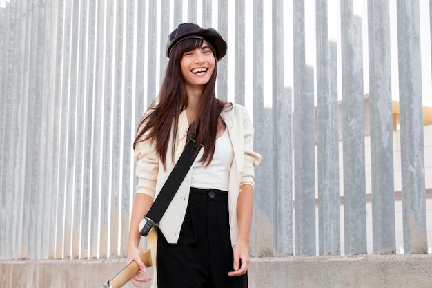 Foto tiro medio mujer sonriente sosteniendo la guitarra