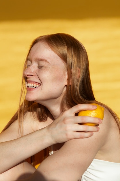 Tiro medio mujer sonriente sosteniendo limón