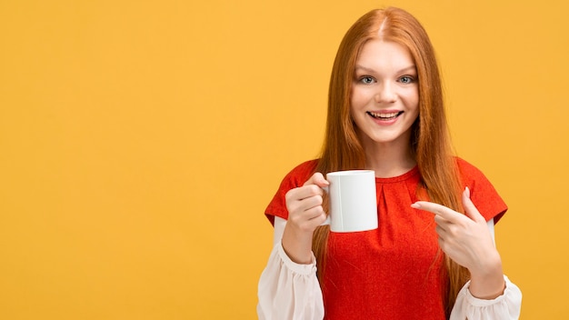 Foto tiro medio mujer sonriente sosteniendo la taza