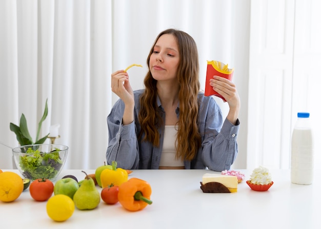 Foto tiro medio mujer sosteniendo papas fritas