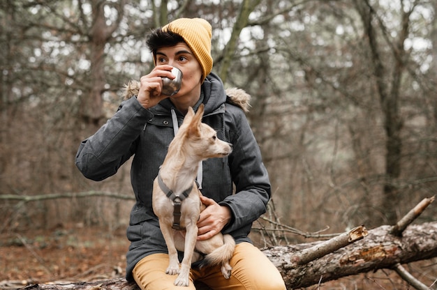 Foto tiro medio mujer sosteniendo perro en el bosque