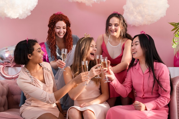 Foto tiro medio mujeres felices tintineando vasos