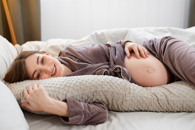 Tiro médio, mulher grávida, deitando cama