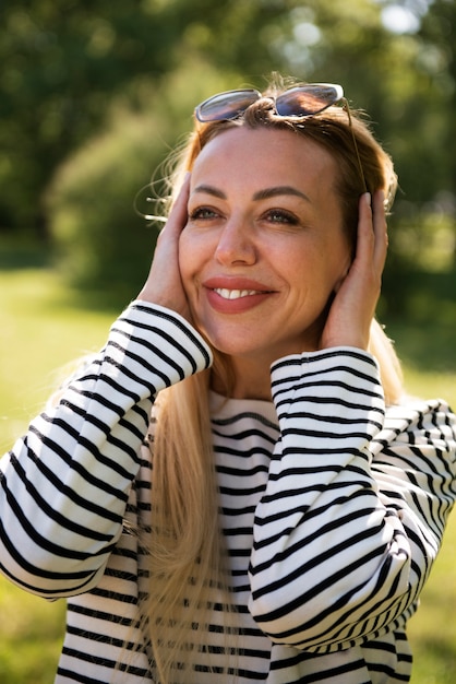 Tiro médio mulher sorridente ao ar livre