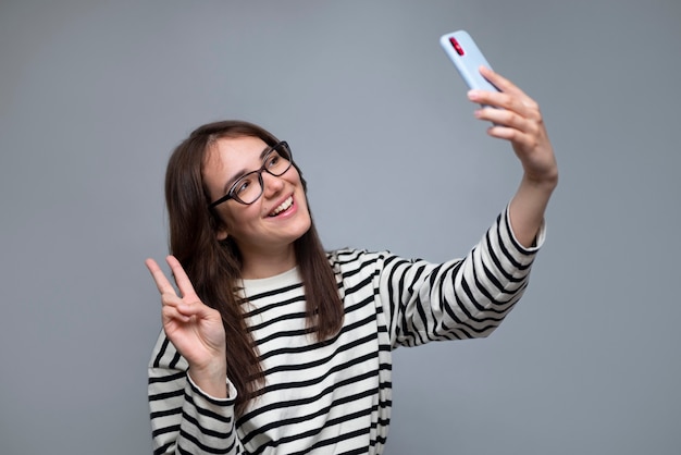 Tiro médio mulher sorridente tomando selfie