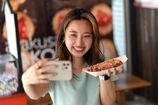 Tiro médio mulher sorridente tomando selfie