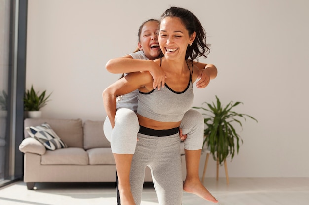 Foto tiro medio, sonriente, mujer, tenencia, niña