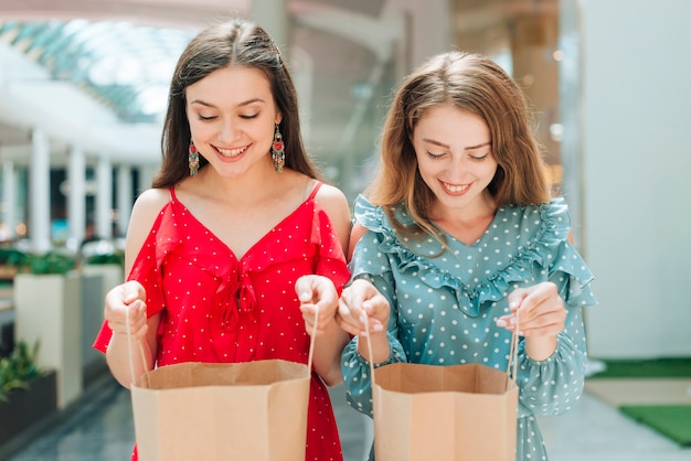 Tiro médio, sorrindo, meninas, olhar, dentro, sacolas