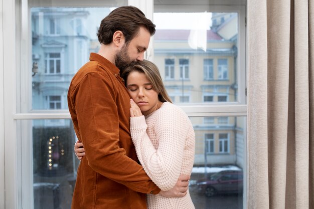 Foto tiro medio triste pareja abrazándose