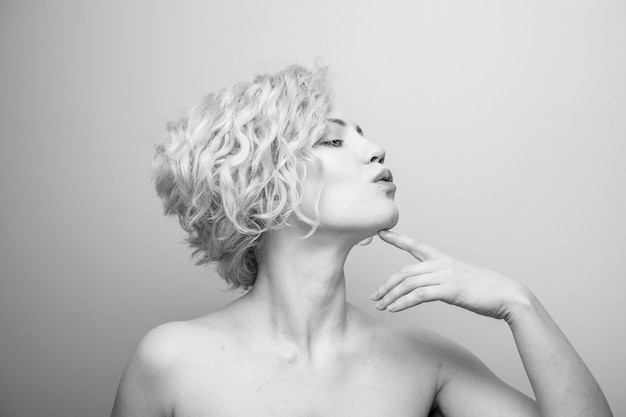 Tiro na cabeça de uma linda jovem atraente com cabelos cacheados sorrindo. Imagem em preto e branco. Marilyn Monroe.