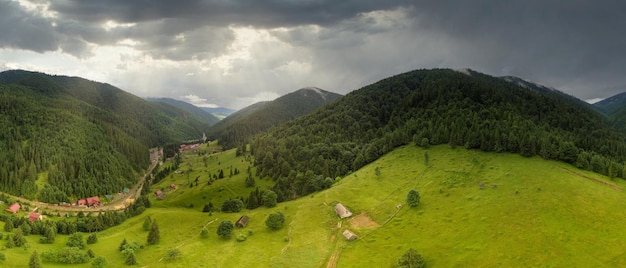 Tiro panorâmico grande angular de belas colinas de prados e árvores na clareira Synevyrska ao lado do lago Synevyr Paisagens majestosas e maravilhosas das montanhas dos Cárpatos na Ucrânia