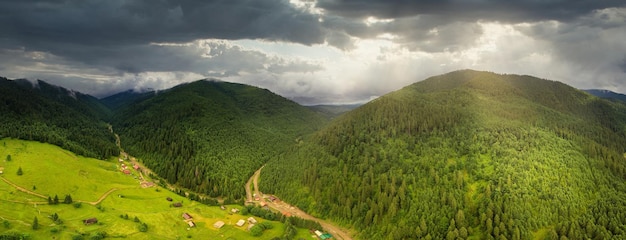 Tiro panorâmico grande angular de belas colinas de prados e árvores na clareira Synevyrska ao lado do lago Synevyr Paisagens majestosas e maravilhosas das montanhas dos Cárpatos na Ucrânia