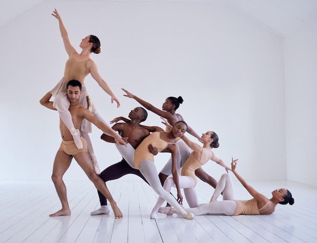 Tiro perfeitamente posicionado de um grupo de bailarinos praticando uma rotina em um estúdio de dança