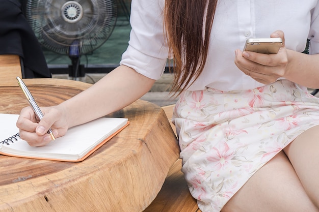 Tiro próximo de uma mão humana escrevendo algo no papel