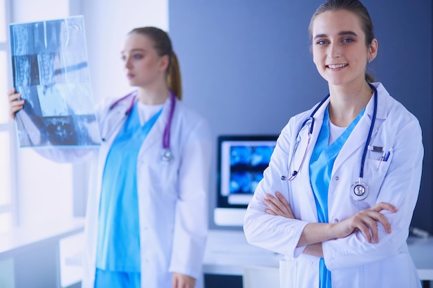 Tiro recortado de dois jovens médicos femininos com estetoscópio.