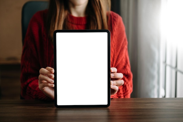 Tiro recortado de mão feminina escrevendo no caderno em branco com lápis na mesa de escritório com caminho de recorte tabletxAxA