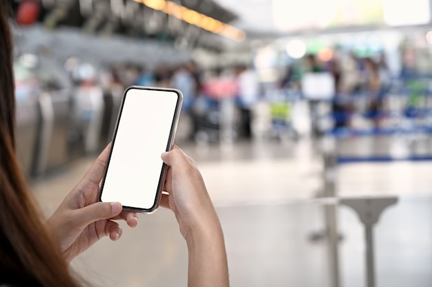 Tiro recortado, de, mão feminina, segurando, telefone móvel, em, aeroporto, terminal