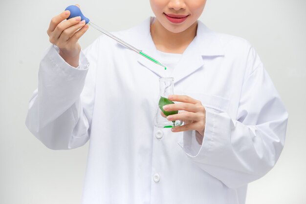 Tiro sincero de la hermosa joven investigadora asiática realizando un experimento en el laboratorio,